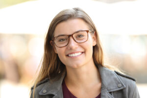 A portrait of a young woman wearing glasses.