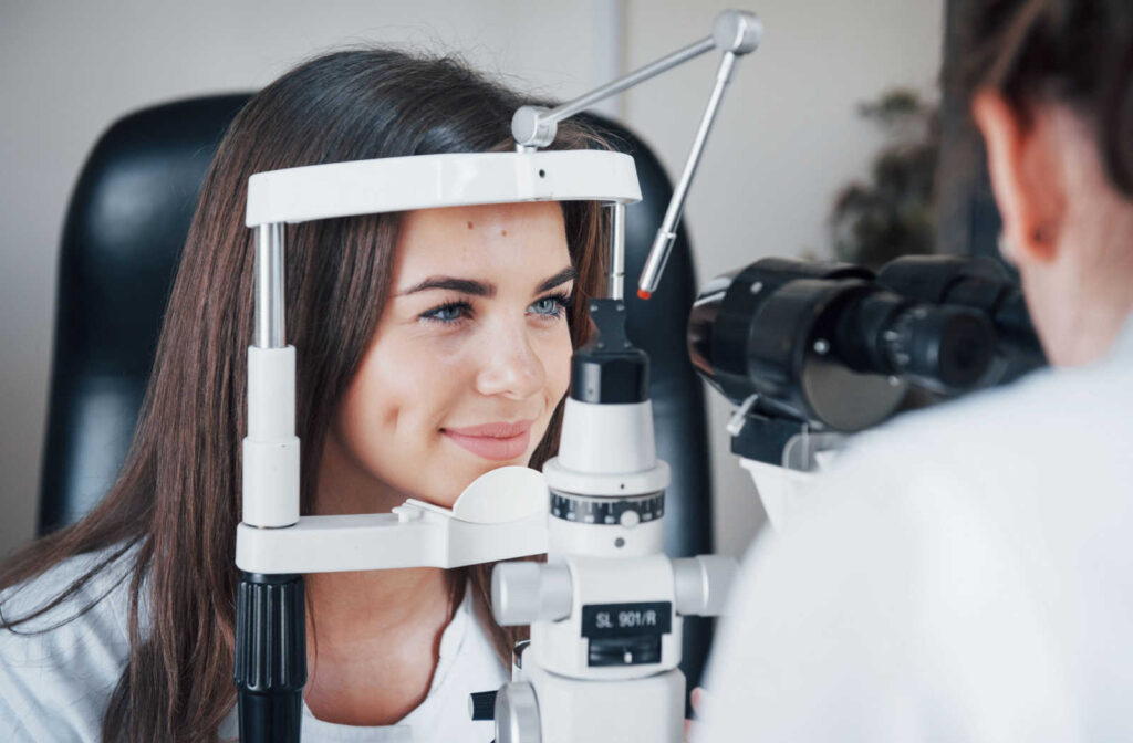 Smiling young woman being examined with a slit lamp.