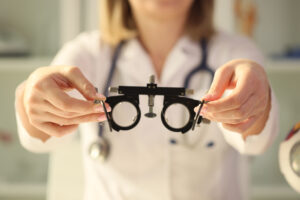 Picture of an eye doctor holding a glasses frame.